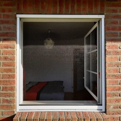 Fliegengitterrollo frontal betrachtet. Um das Fenster herum Backsteinmauern
