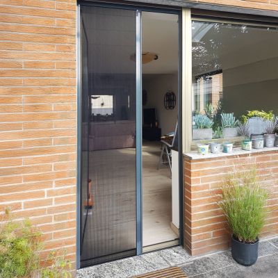 Fliegengitterplissee leicht geöffnet an einer Terrassentür