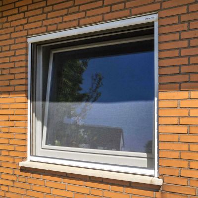 Fliegengitterrollo an Fenster an Haus mit Backsteinen