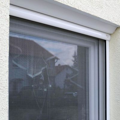 Fliegengitterrollo weiß am Fenster